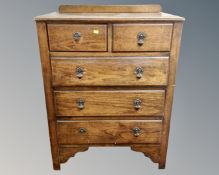 An Edwardian oak five drawer chest