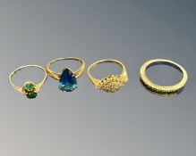 Four dress rings to include - 9ct yellow gold ring set with a blue tear drop shaped stone,