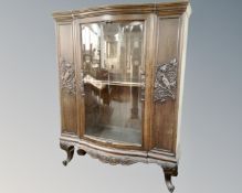 An early 20th century glazed door carved bookcase