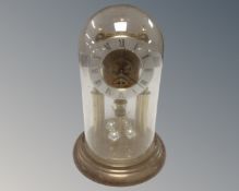 An early 20th century German anniversary clock under shade