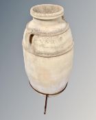 A large pottery twin handled urn on metal stand