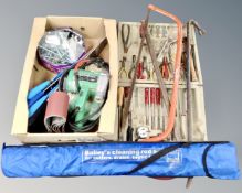 A collection of tools including a large saw, crowbar, belt sander etc.