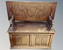 A carved oak storage monk's bench
