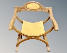 A carved beech wood Savonarola armchair
