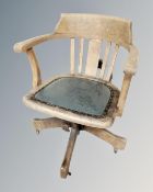 An Edwardian oak captain's swivel armchair.
