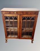 An Edwardian mahogany double door glazed bookcase on claw and ball feet.