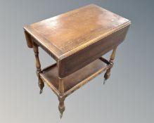 An oak flap sided two tier tea trolley fitted with a drawer.