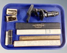A tray containing a vintage student microscope together with three calculating rules, one by A. W.