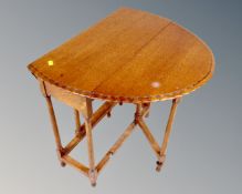 An Edwardian oak gateleg occasional table.