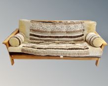 A pine folding bed settee with cover and cushions.