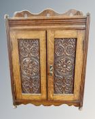 A 19th century carved oak double door smoker's cabinet.