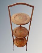 An Edwardian mahogany three tier folding cake stand.