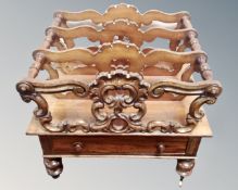 A Victorian mahogany Canterbury fitted with a drawer below, on brass castors,