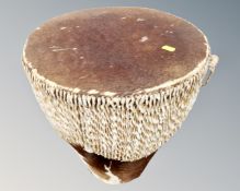 An East African floor standing drum upholstered in animal hide.