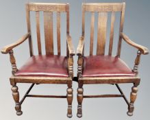 A pair of 1930s oak open armchairs.