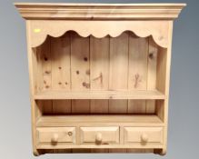 A pine farmhouse hanging wall shelf, fitted with three drawers.