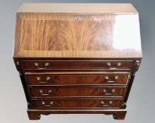 A Regency style inlaid mahogany writing bureau fitted with four drawers beneath and column supports,