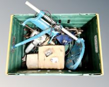 A crate containing ring spanners, rail spikes, electric drill on stand.