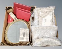Two boxes containing assorted table linen, oval gilt framed bevel edged dressing mirror,