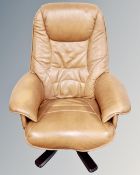 A Danish brown leather swivel reclining armchair.