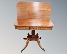A Regency mahogany D-shaped turnover topped tea table on four way pedestal with brass capped feet,