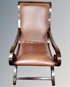 A contemporary Regency style open armchair upholstered in brown leather.