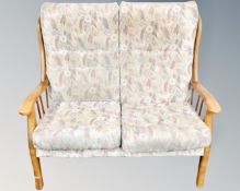 A beech framed high backed two seater settee,