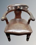 A 19th century open captain's armchair upholstered in brown leather.