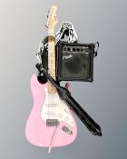 A pink Nevada electric guitar, together with a Nevada G-10 guitar amplifier and a microphone stand.
