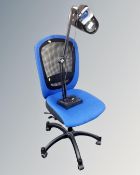 A blue fabric and mesh upholstered swivel typist's chair together with an angle poise lamp.
