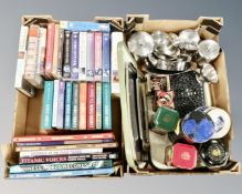 Two boxes containing stainless steel teaware and trays, tins, cast metal pan stands,