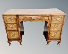 A 20th century walnut twin pedestal breakfront dressing table fitted with seven drawers, no mirror,