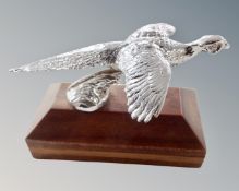 A pheasant car mascot, mounted on a wooden plinth.