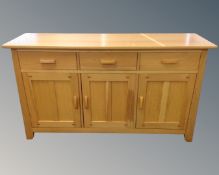 A contemporary oak triple door sideboard.