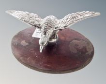 A duck car mascot, mounted on a wooden plinth.