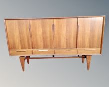 A Scandinavian teak sliding door sideboard on raised legs.