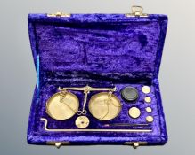 A set of brass portable balance scales in fitted case, with weights and tweezers.