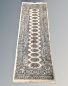 A Lahore Bokhara runner, Pakistan, on coffee ground, 184cm by 65cm.