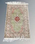 A Turkish Anatolian fringed rug on green ground, 150cm by 87cm.