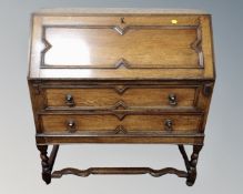 A 1930s oak bureau on barley twist legs.