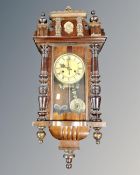 A late 19th century 8-day wall clock with pendulum and key.