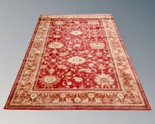A Royal Keshan machine made floral patterned carpet on red ground