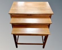 A nest of three mid century teak tables