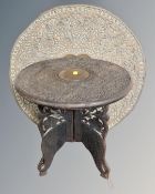 An Indian carved hardwood occasional table together with a copper embossed charger,