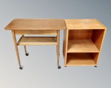 A mid century teak two tier coffee table on castors together with a further teak shelving unit