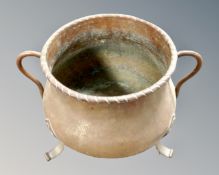 A 19th century copper twin handled cooking pot on feet, diameter 21.