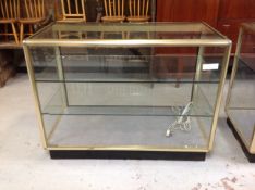 A metal framed shop display cabinet with two internal shelves (no doors),