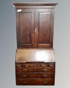 A George III oak bureau bookcase with panel doors fitted with six drawers