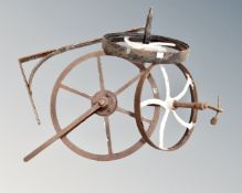 Three antique cast iron fly wheels together with a wall bracket