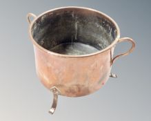 A 19th century copper Art Nouveau twin handled pot on raised feet, diameter 26 cm.